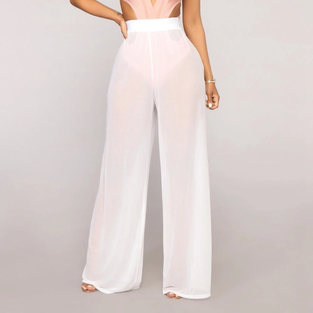 Model wearing Echo & Air women's Sheer Wide Leg Pants in white, showcasing the bohemian high-waisted silhouette and semi-transparent mesh fabric.