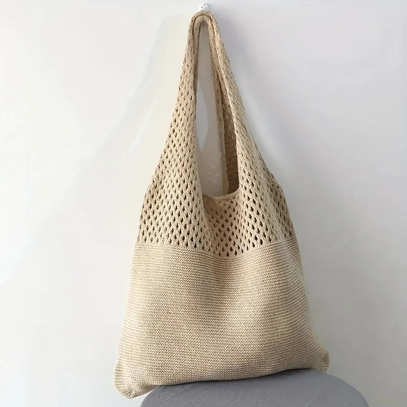 Echo & Air beige crochet knit tote bag hanging from a wall hook against a minimalist background.
