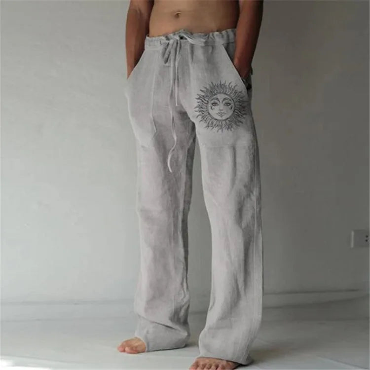 Model wearing Echo & Air men's Driftwood Slit Lounge Pant in light gray featuring a prominent graphic sun design on the left leg.