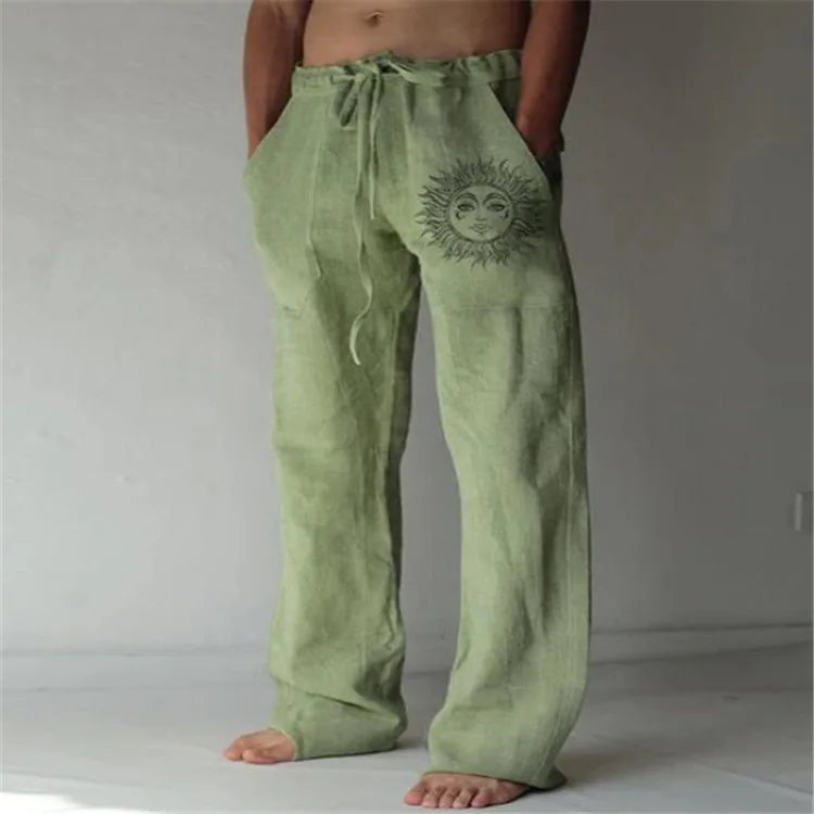 Model wearing Echo & Air men's Driftwood Slit Lounge Pant in green featuring a prominent graphic sun design on the left leg.