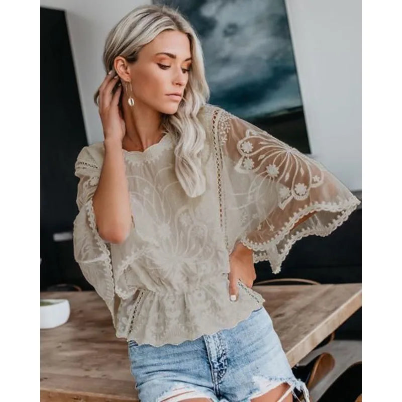 Model wearing the Echo & Air elegant floral lace batwing blouse in beige paired with light wash denim shorts.