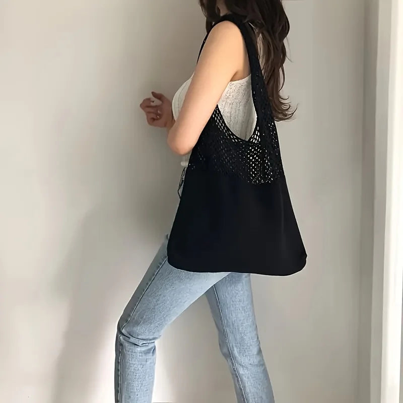 Model wearing the Echo & Air black crochet knit tote bag over one shoulder with white top and jeans.