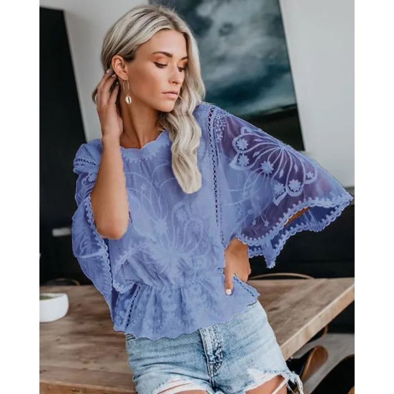 Model wearing the Echo & Air elegant floral lace batwing blouse in blue paired with light wash denim shorts.