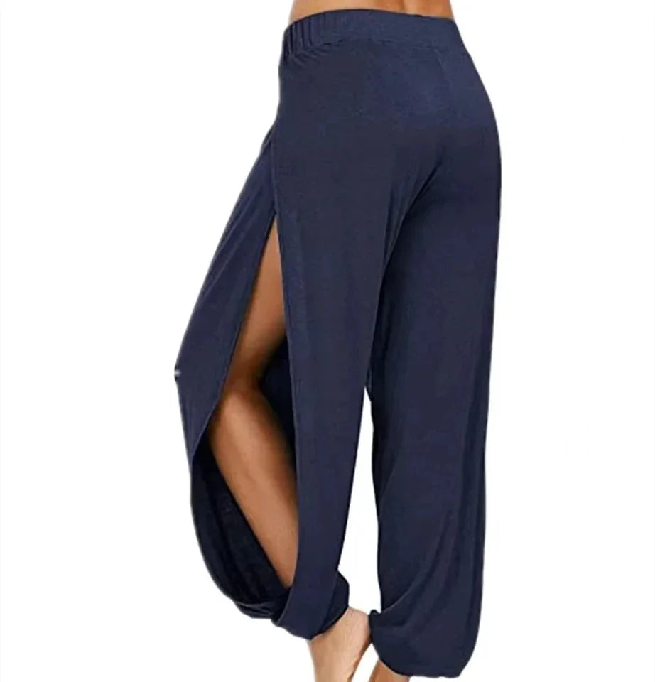 Model from the side wearing Echo & Air women's Ethereal Side-Slit Lounge Pants in navy blue showcasing the high side leg slit and relaxed harem fit.